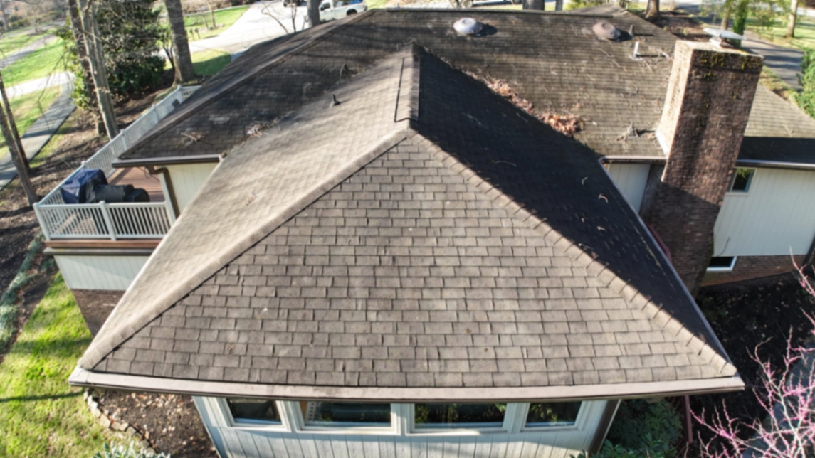 Roof with black algae streaks and moss buildup before soft wash cleaning in Mocksville NC